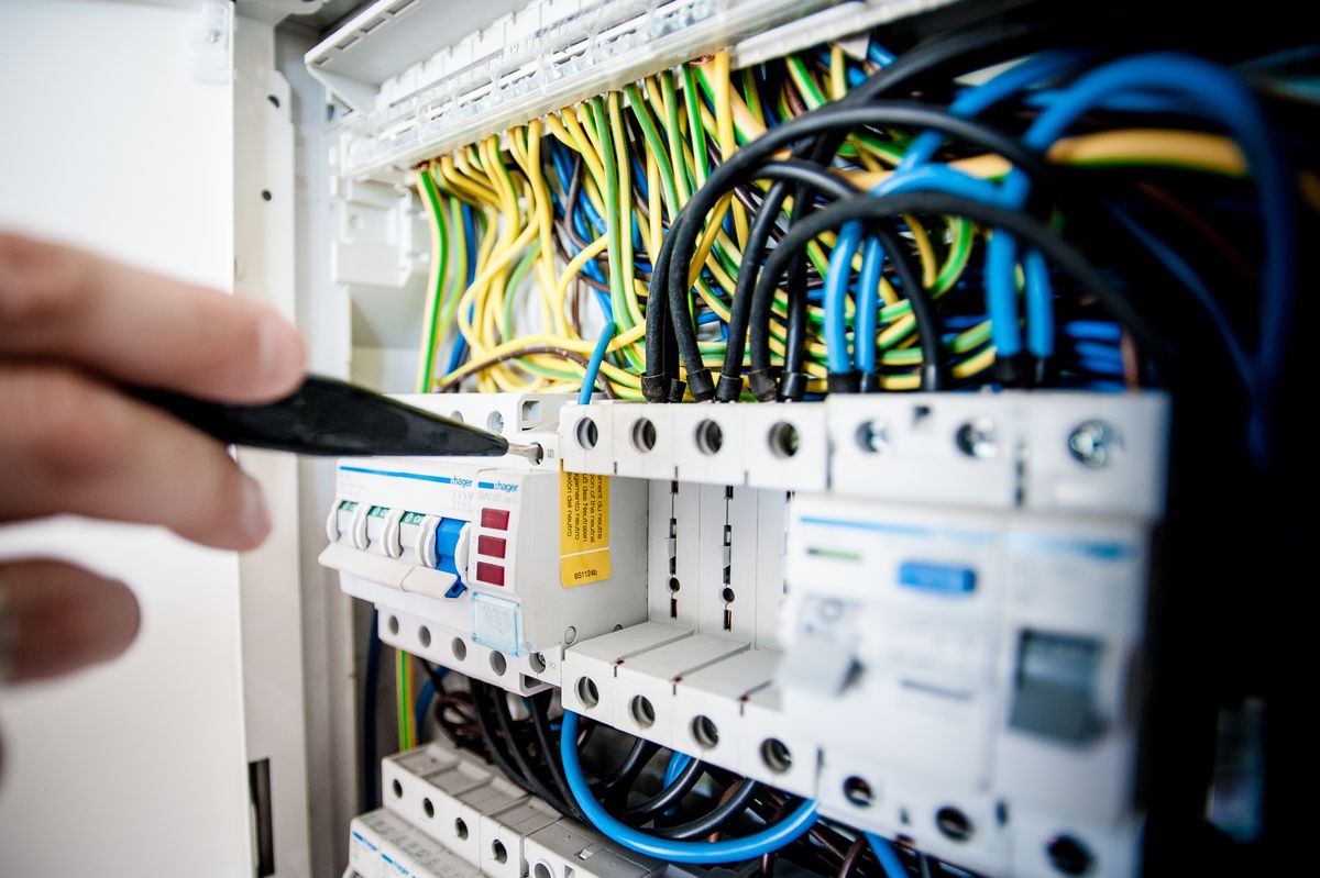 Elektryk pracujący przy rozdzielnicy — prace w toku